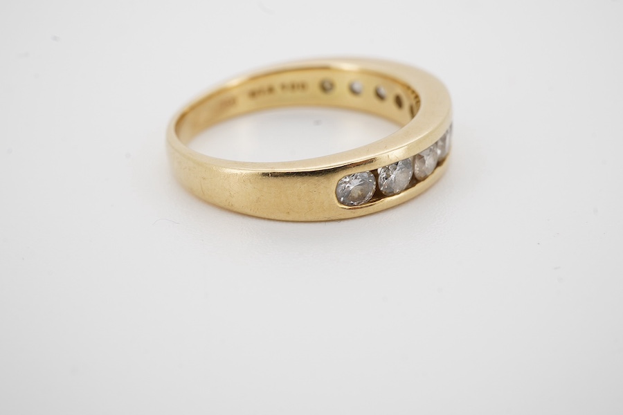 A modern 18ct gold and ten stone channel set diamond half hoop ring, size Q, gross weight 5.8 grams. Condition - fair to good